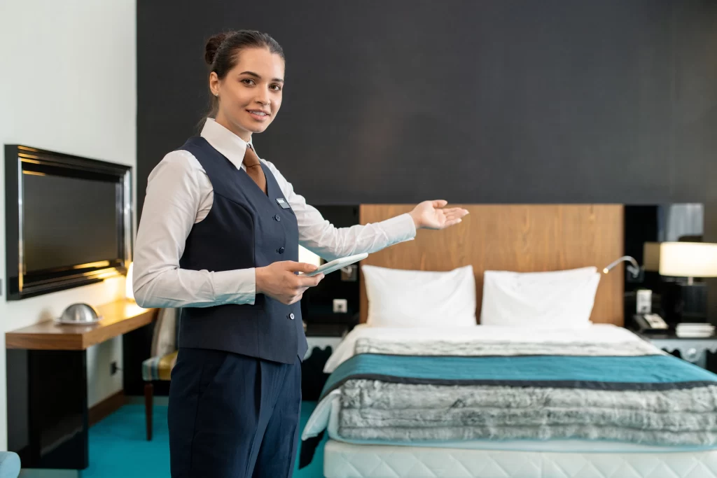 Foto de uma gerente de hotel mostrando um dos seus quartos